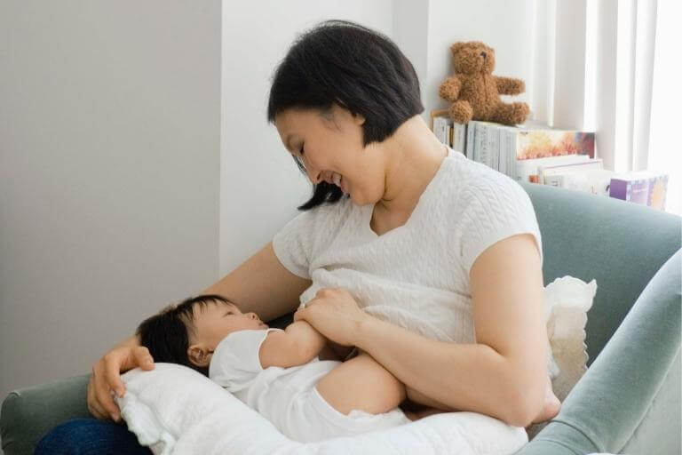 Asian mother breast feeds new born baby
